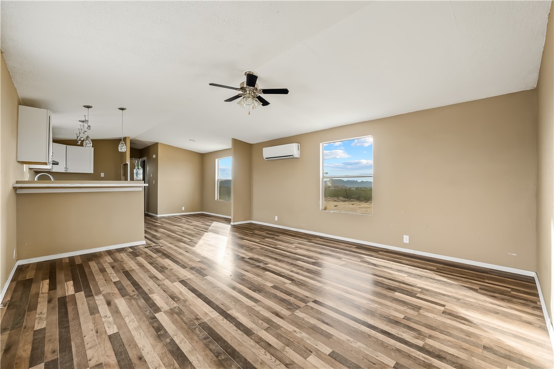 3649 Araby Road Golden Valley, AZ 86413 - Photo 9 of 29 Open-concept living space with wood-finish flooring, a ceiling fan, and multiple windows