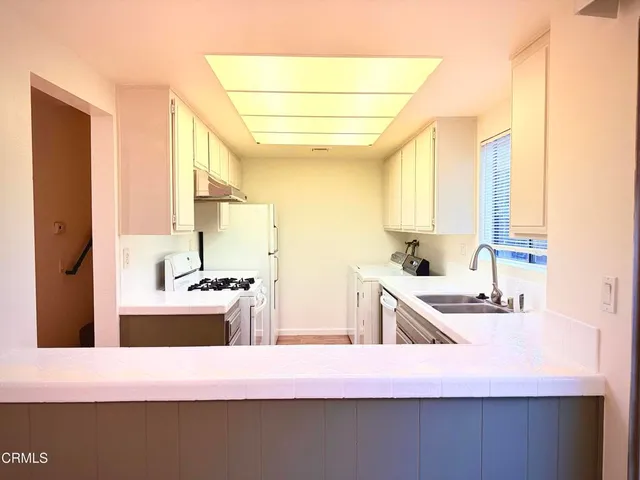 a kitchen with kitchen island granite countertop a sink stove and cabinets