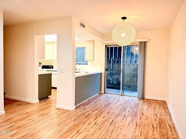 a view of a kitchen with wooden floor and a ceiling fan