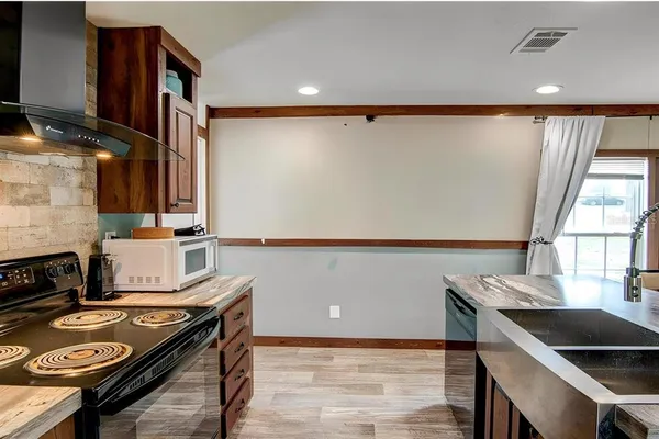 a kitchen with a table chairs a stove and a microwave