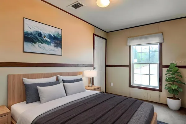 a bedroom with a bed and a painting on the wall