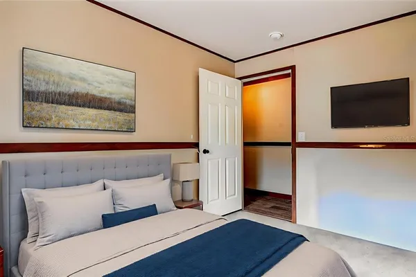 a bedroom with a bed and a flat screen tv
