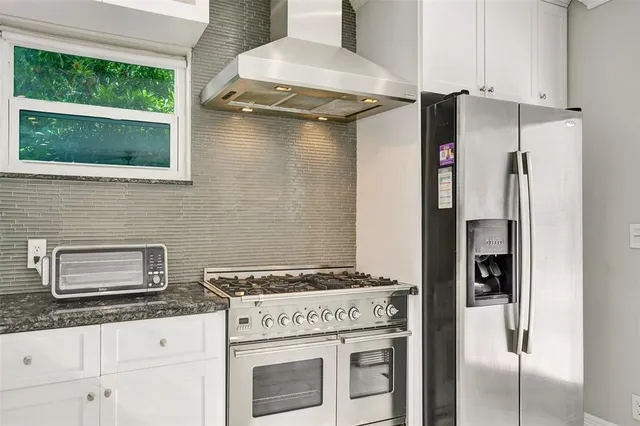 a kitchen with granite countertop a stove and a refrigerator