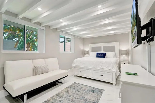 a bedroom with a bed a flat screen tv and a couch