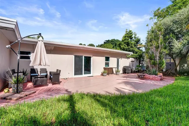 a view of a house with backyard and sitting area