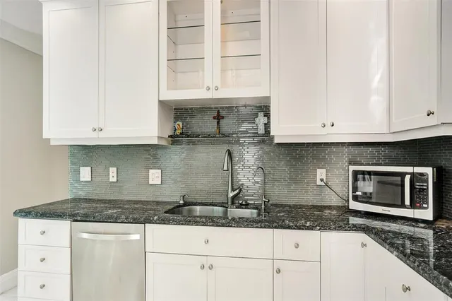 a kitchen with granite countertop white cabinets and a counter space