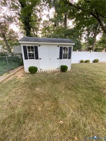a view of a house with a backyard and a tree