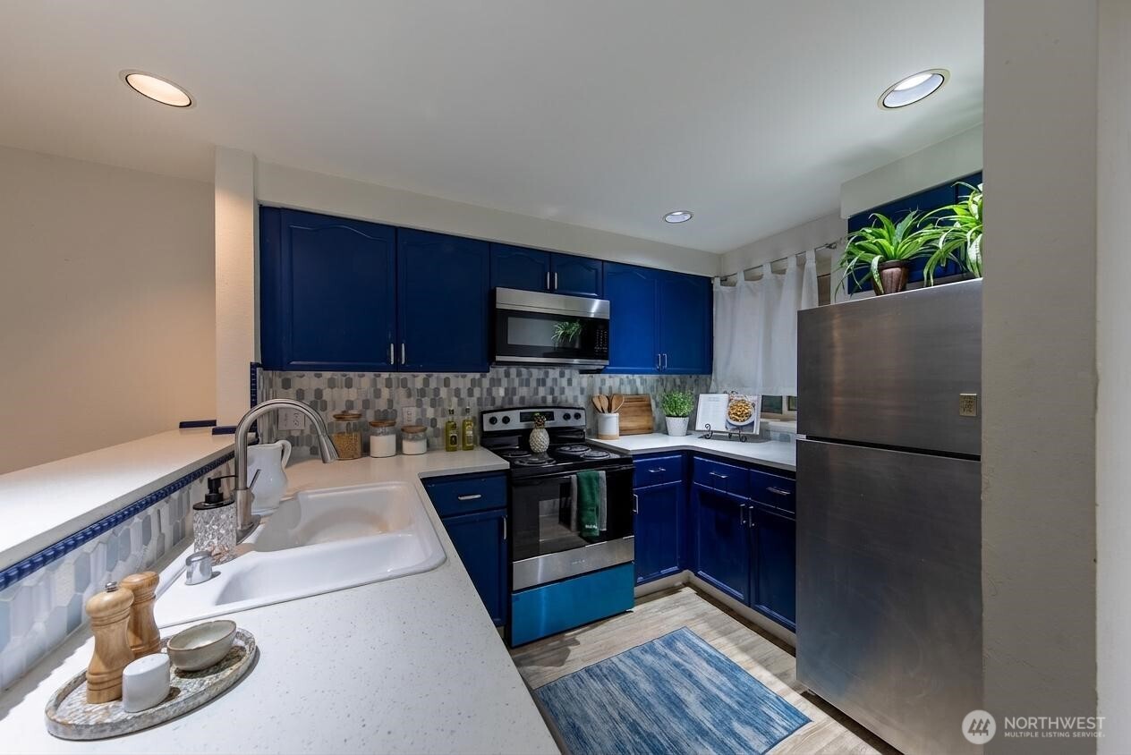 15917 Waynita Way Northeast, Unit E206 Bothell, WA 98011 - Photo 6 of 22 a kitchen with a refrigerator and a sink