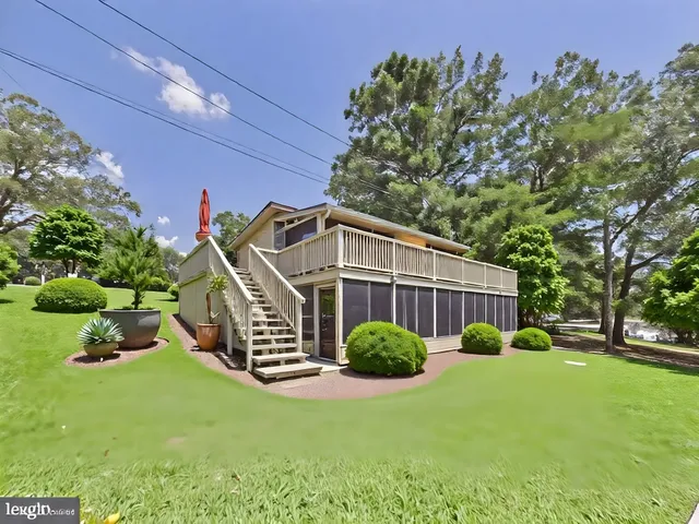 a view of a house with a yard and a wooden deck
