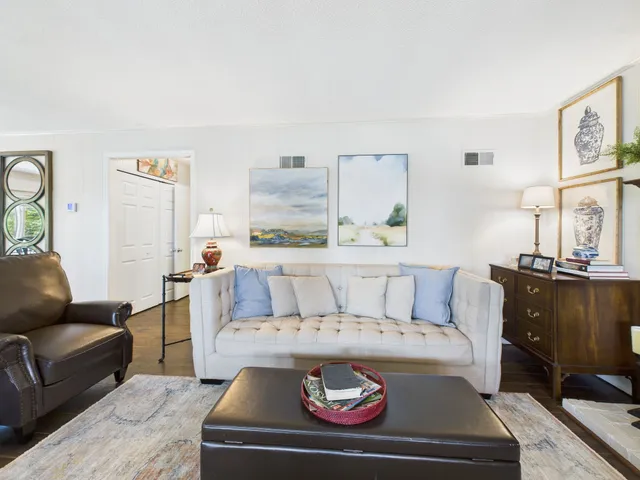 a spacious bedroom with a bed a couch and potted plant on the table