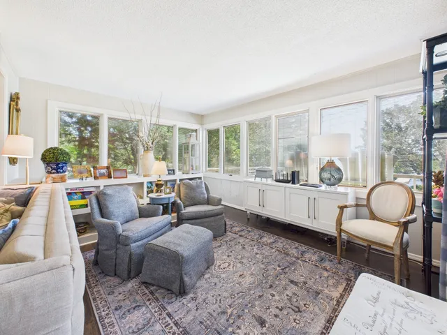 a living room with furniture and a floor to ceiling window next to a large building