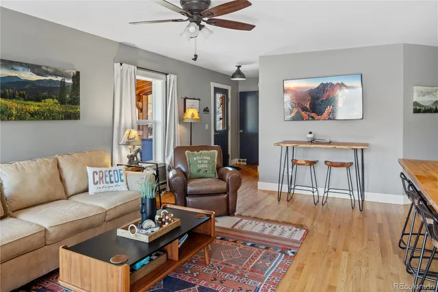 a living room with furniture a wooden floor and a flat screen tv