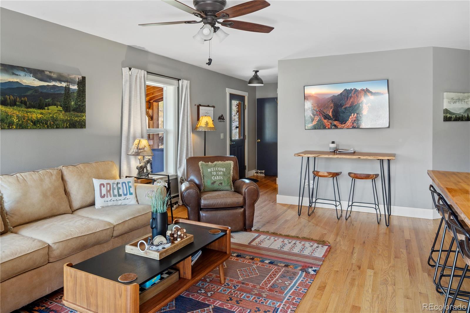 301 West 3rd Street Creede, CO 81130 - Photo 5 of 24 a living room with furniture a wooden floor and a flat screen tv