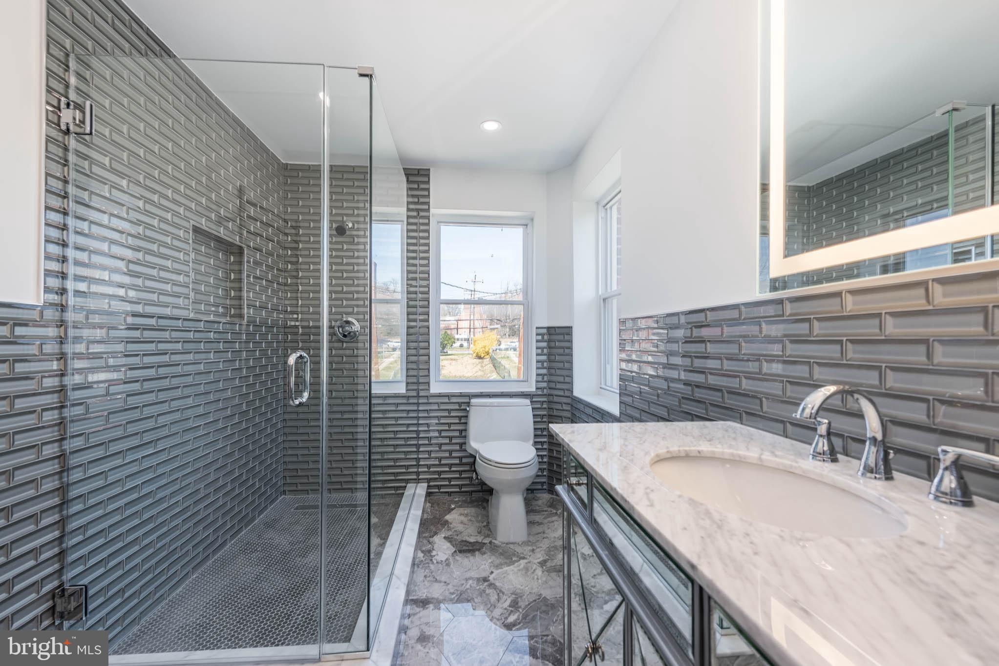 1510 Northbourne Road Baltimore, MD 21239 - Photo 16 of 32 a bathroom with a granite countertop sink a toilet and shower