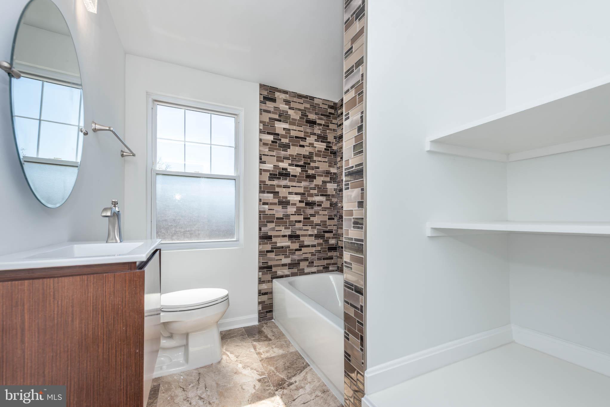 1510 Northbourne Road Baltimore, MD 21239 - Photo 20 of 32 a bathroom with a toilet a sink and bathtub
