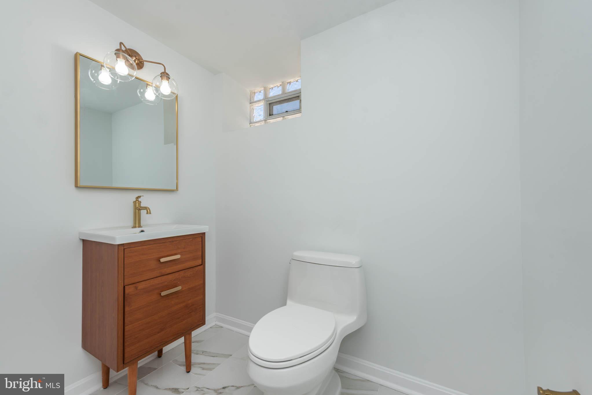1510 Northbourne Road Baltimore, MD 21239 - Photo 27 of 32 a bathroom with a toilet a sink and mirror