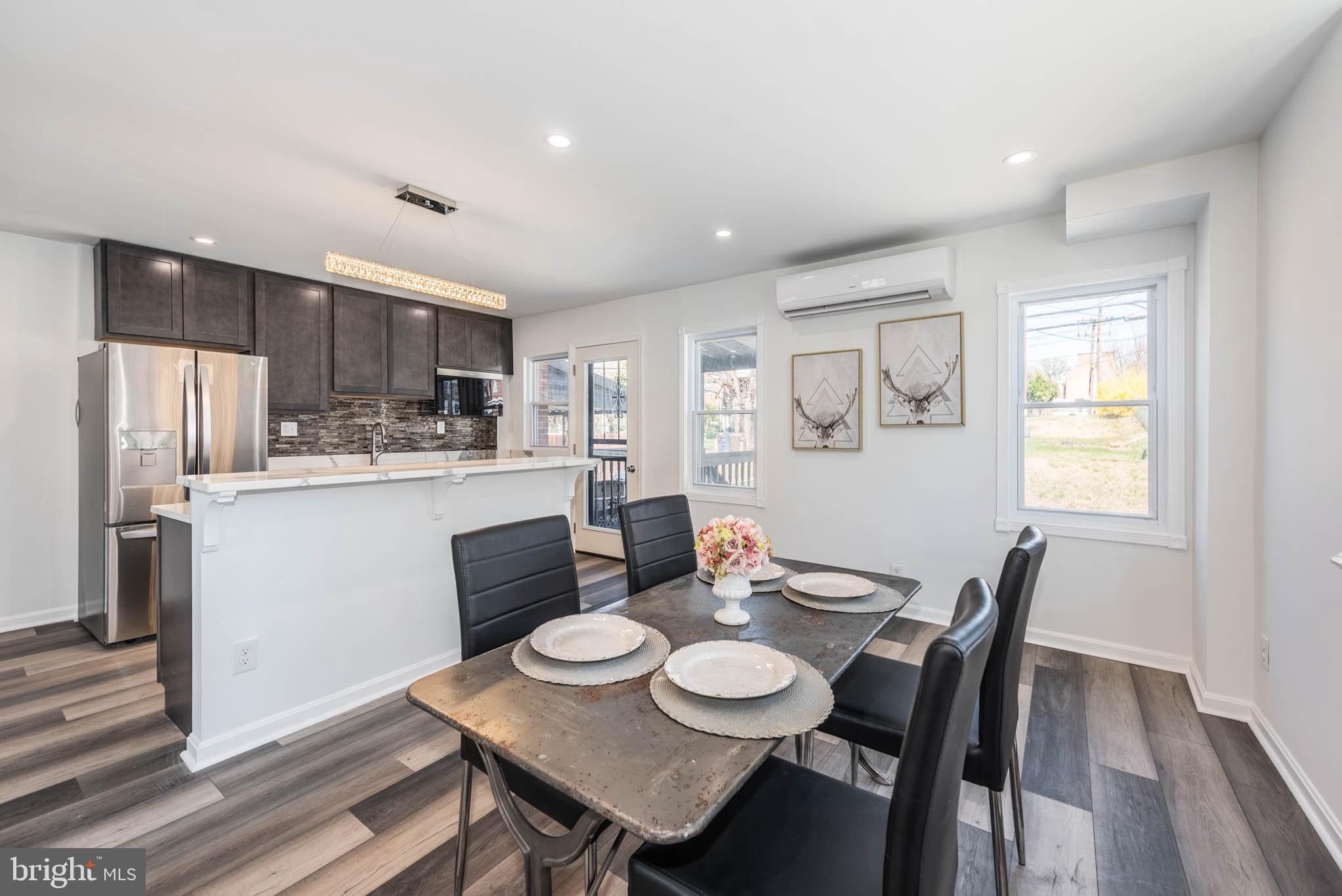 1510 Northbourne Road Baltimore, MD 21239 - Photo 7 of 32 a kitchen with stainless steel appliances kitchen island granite countertop a dining table chairs and refrigerator