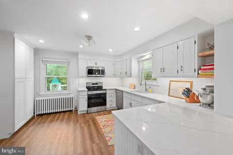 a kitchen that has a lot of cabinets a sink and appliances in it