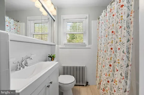 a bathroom with a sink toilet and window
