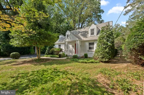 a view of a house with backyard and a tree