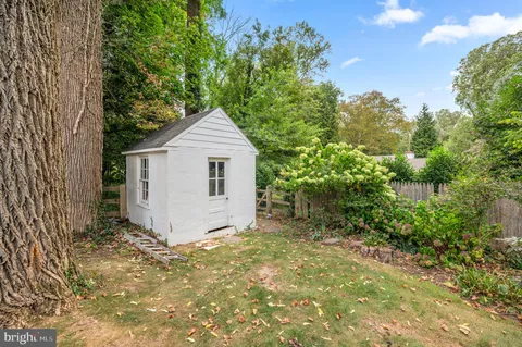 a view of a house with a small yard and large tree