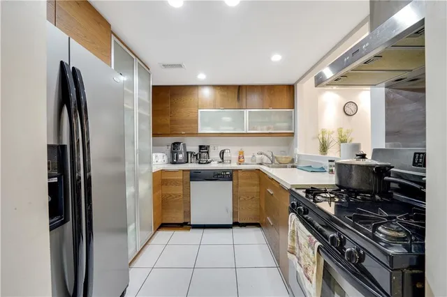 a kitchen with stainless steel appliances granite countertop a refrigerator and a sink