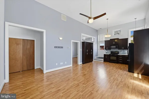 a view of a kitchen with refrigerator and wooden floor