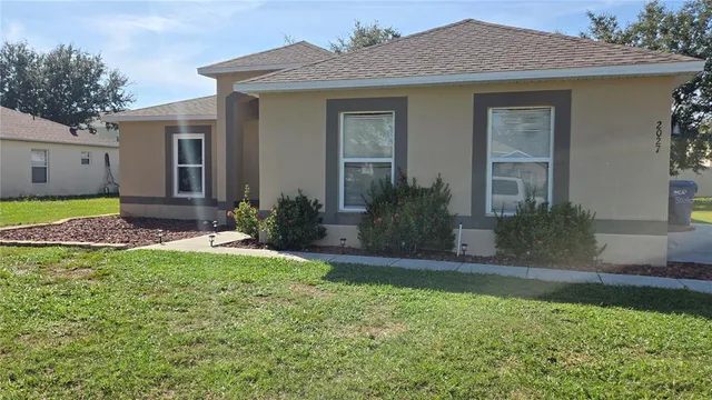 a living room with furniture a flat screen tv and kitchen view