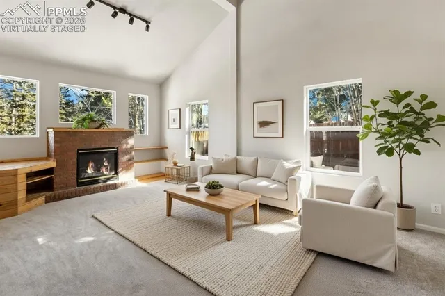 a view of a room with furniture a fireplace and windows