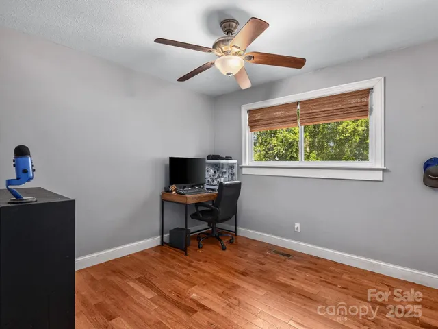 a workspace with wooden floor and a window
