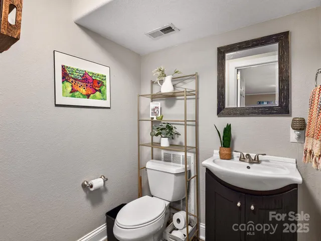 a bathroom with a toilet a sink and mirror