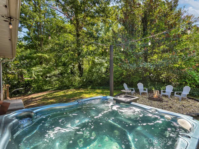 a view of swimming pool with lawn chairs and plants