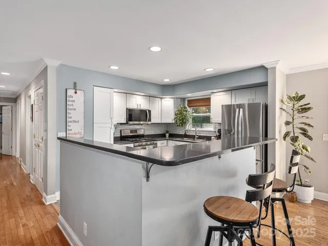 a kitchen with stainless steel appliances kitchen island granite countertop a sink and cabinets