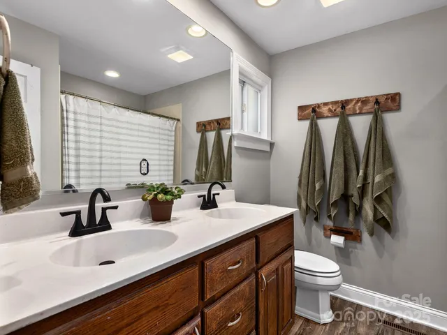 a bathroom with a double vanity sink toilet and mirror