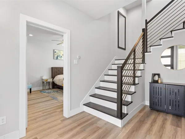 a view of a hallway with wooden floor and stairs