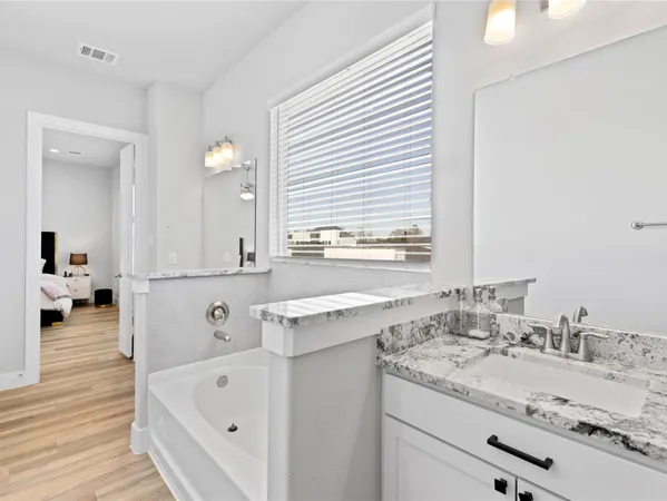 a bathroom with a tub sink and mirror