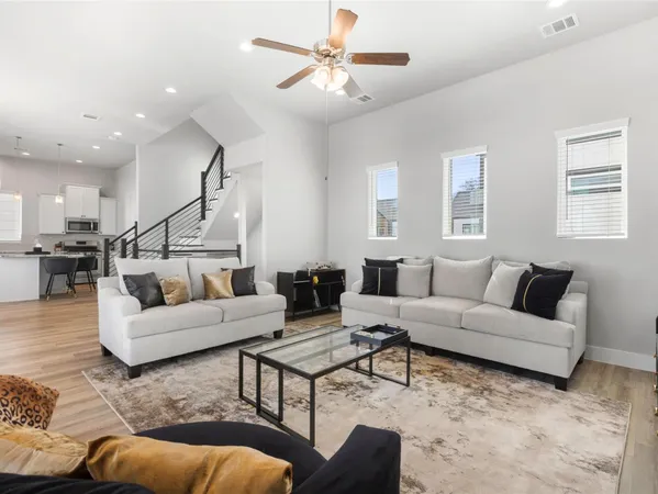a living room with furniture and a view of kitchen