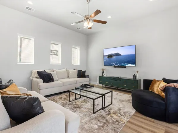 a living room with furniture a flat screen tv and a window
