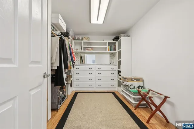 a view of walk in closet with clothes and shoes