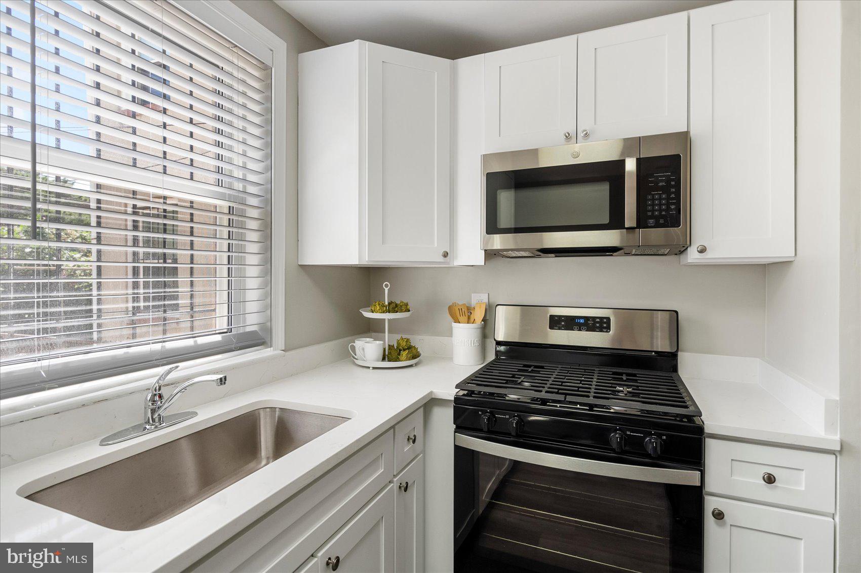 535 Mosher Street Baltimore, MD 21217 - Photo 11 of 28 a kitchen with stainless steel appliances a stove a microwave a sink and cabinets