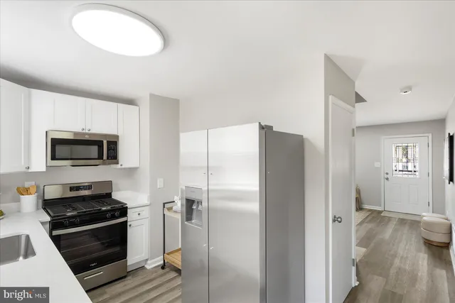 a kitchen with stainless steel appliances a refrigerator a stove a microwave and cabinets