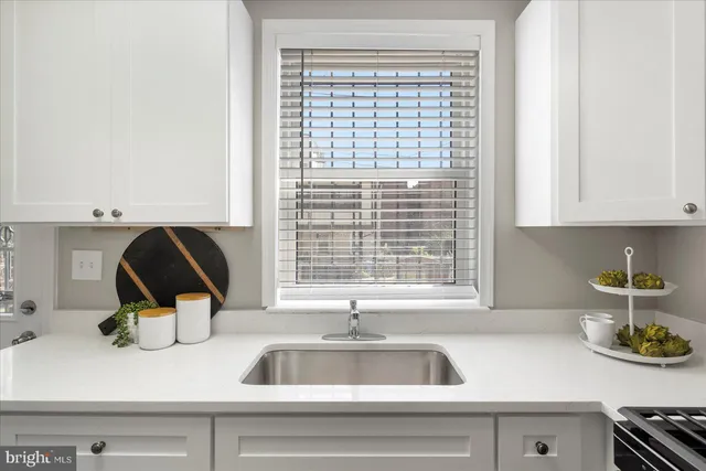 a kitchen with a sink and a stove next to a window