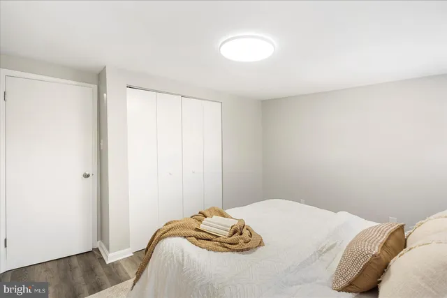 a bedroom with a bed and a wooden floor