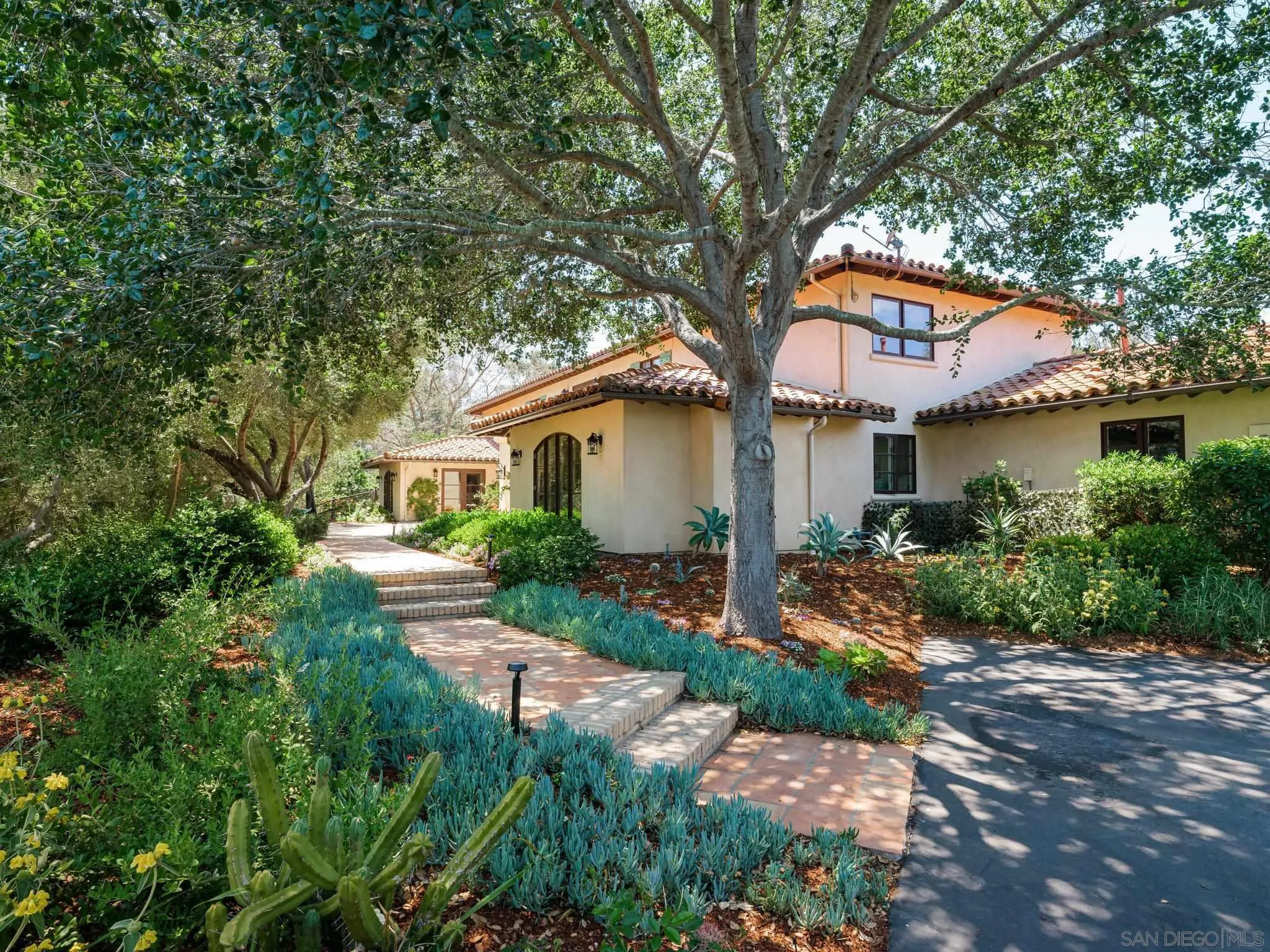 a front view of a house with a garden and outdoor seating