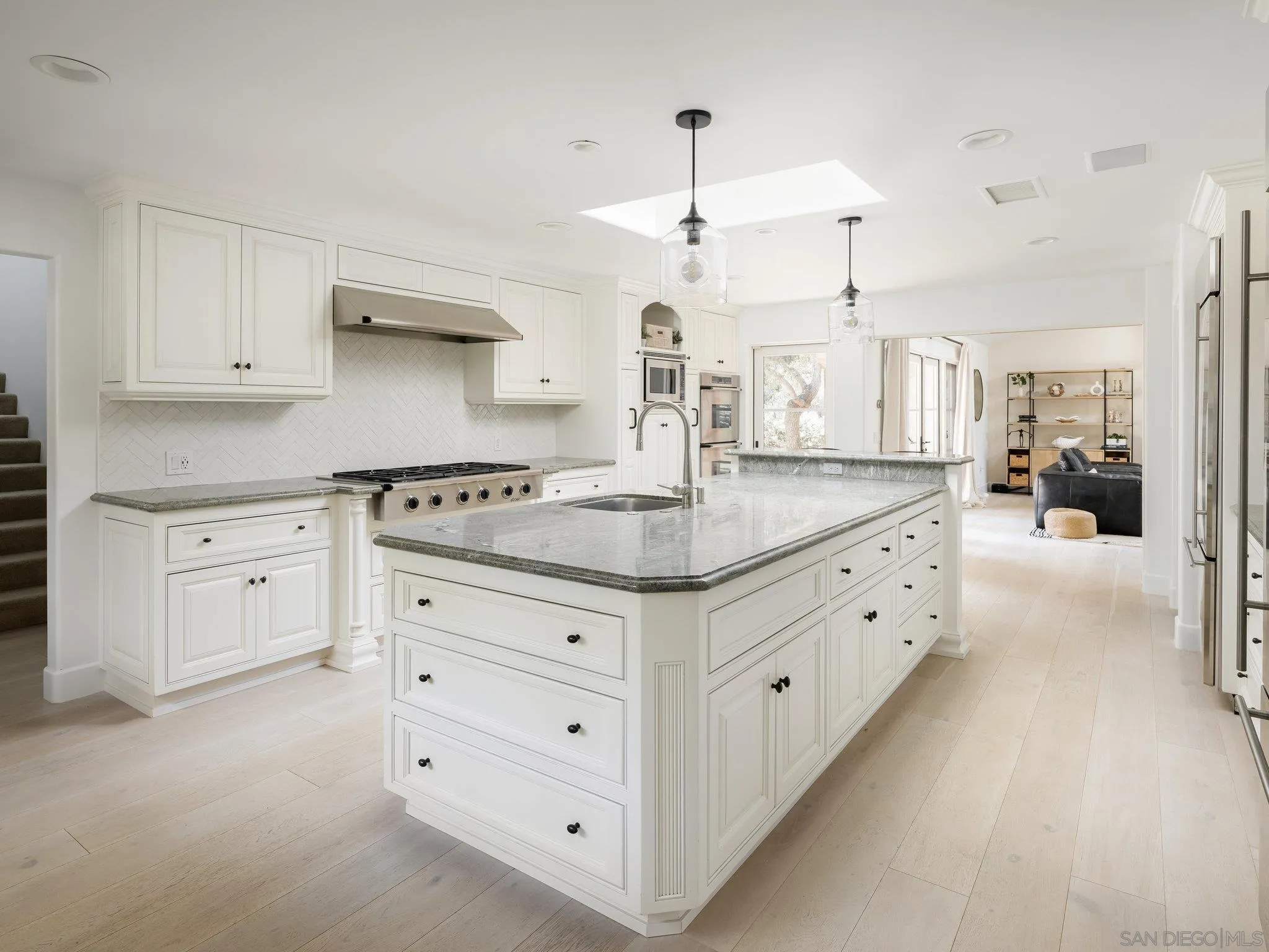16338 Via Del Alba Rancho Santa Fe, CA 92067 - Photo 29 of 46 a kitchen with granite countertop a white stove a sink and dishwasher with white cabinets
