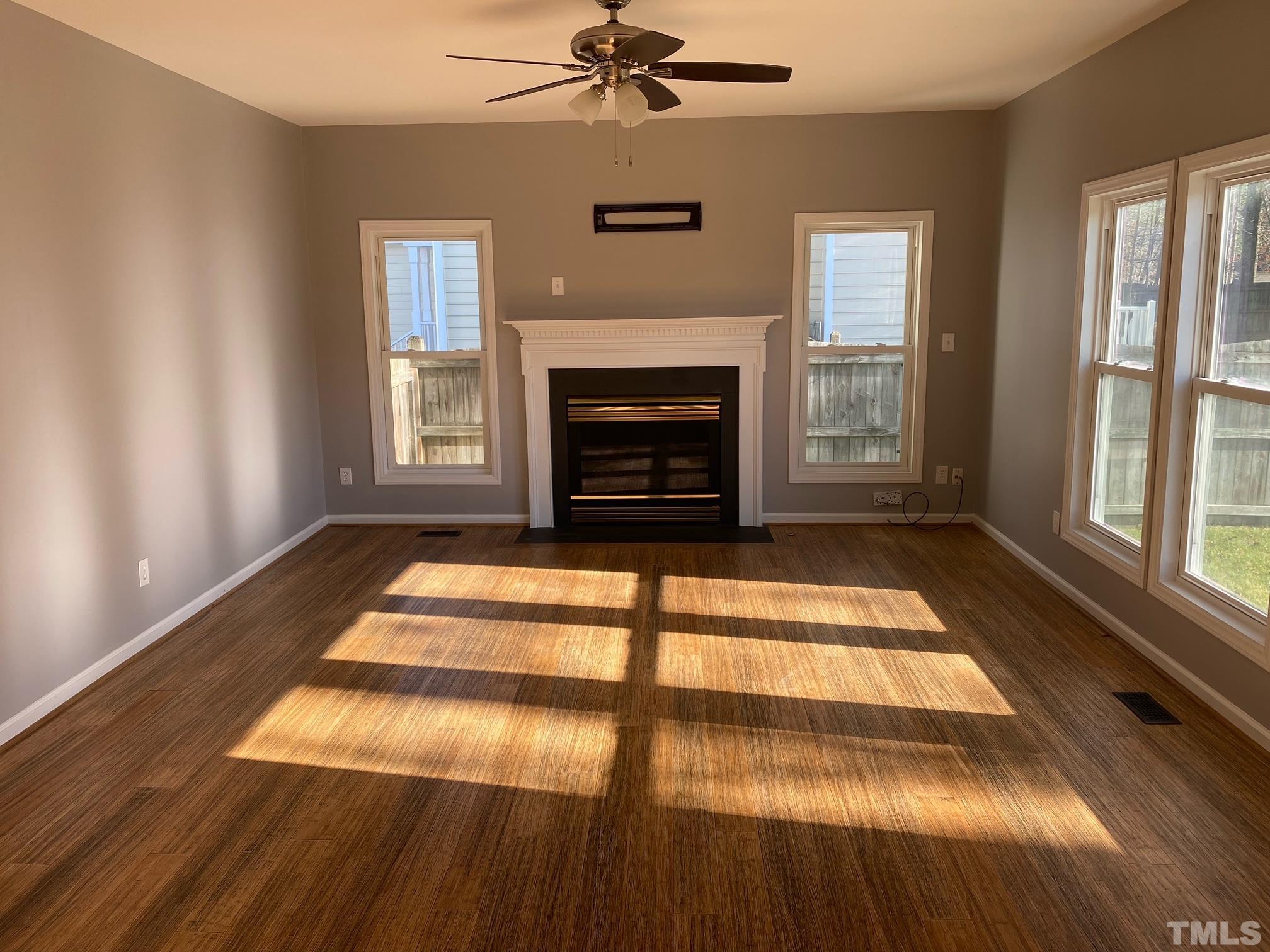 9821 Rockledge Drive Raleigh, NC 27617 - Photo 12 of 26 a living room with a fireplace and a floor to ceiling window