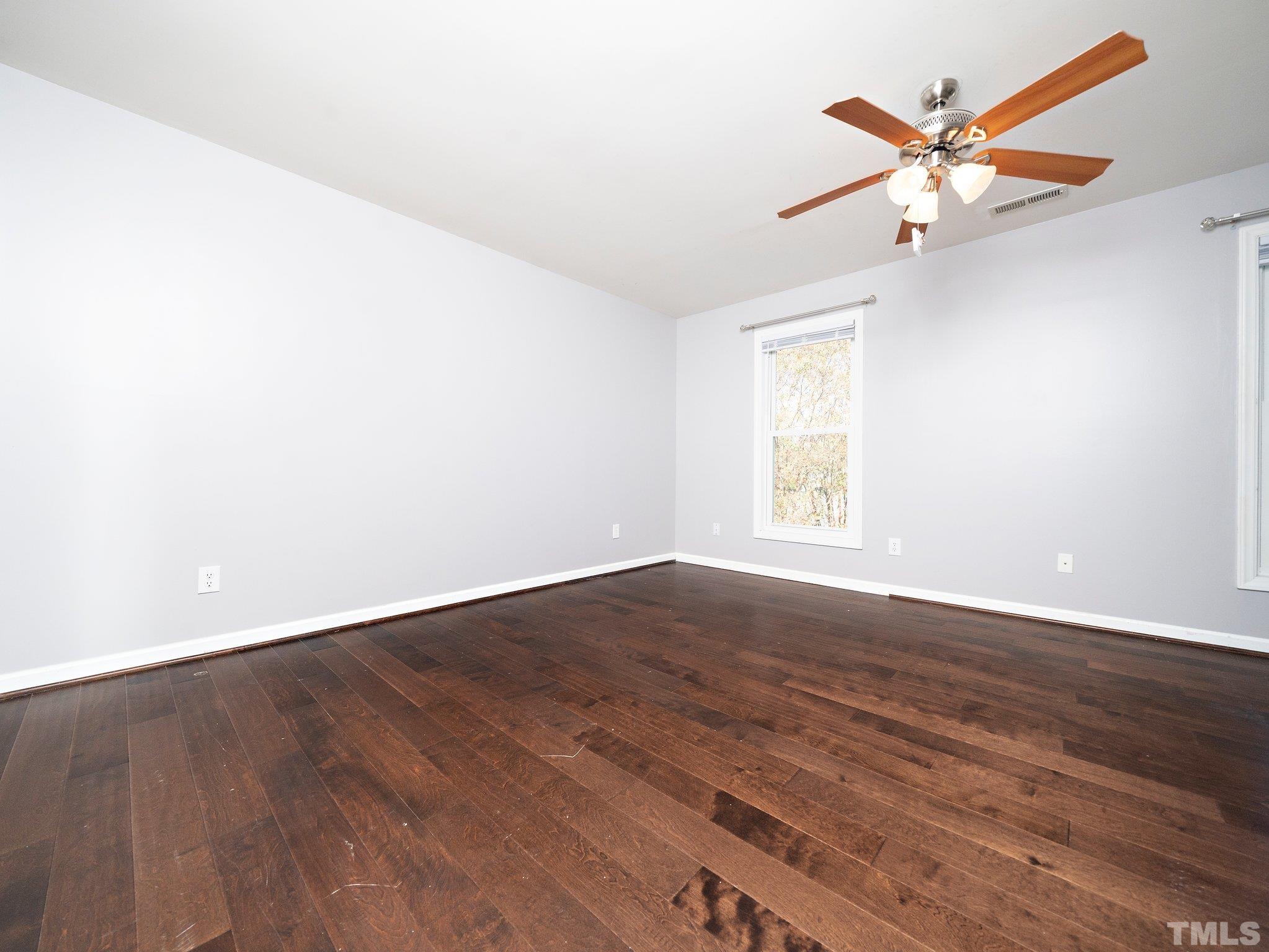 9821 Rockledge Drive Raleigh, NC 27617 - Photo 20 of 26 an empty room with wooden floor and ceiling fan