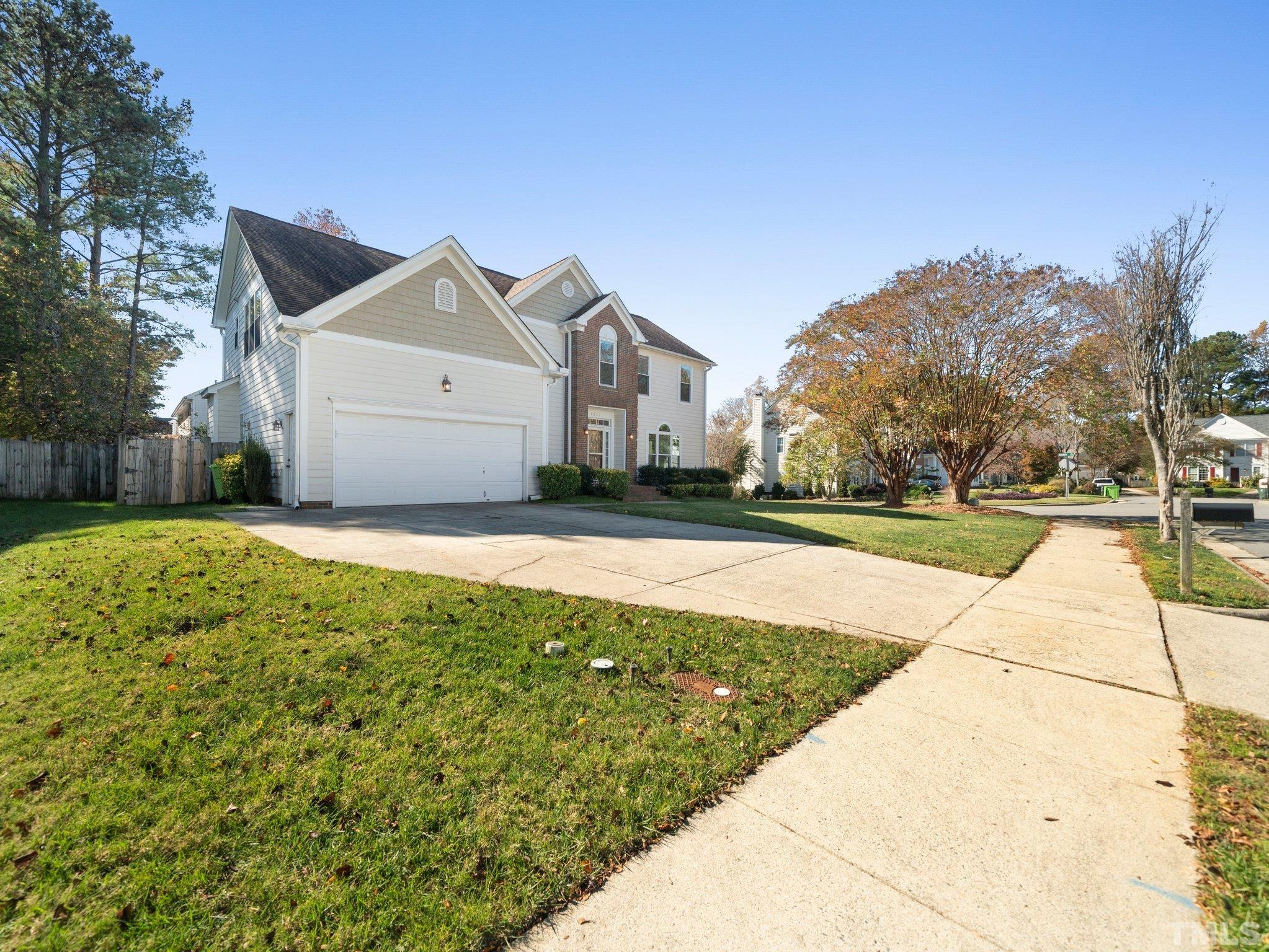 9821 Rockledge Drive Raleigh, NC 27617 - Photo 2 of 26 a view of a big house with a big yard and large trees