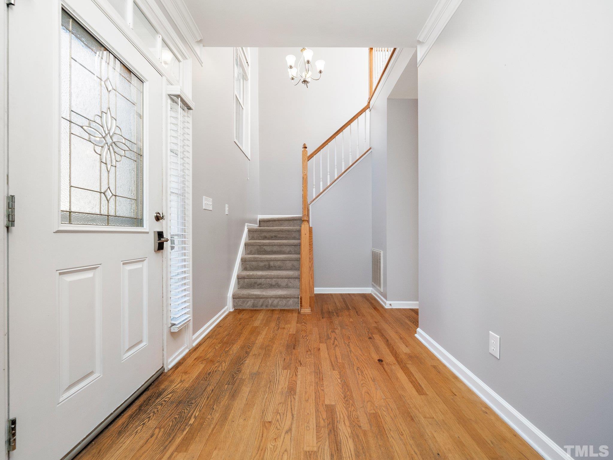 9821 Rockledge Drive Raleigh, NC 27617 - Photo 4 of 26 a view of a room with wooden floor and staircase