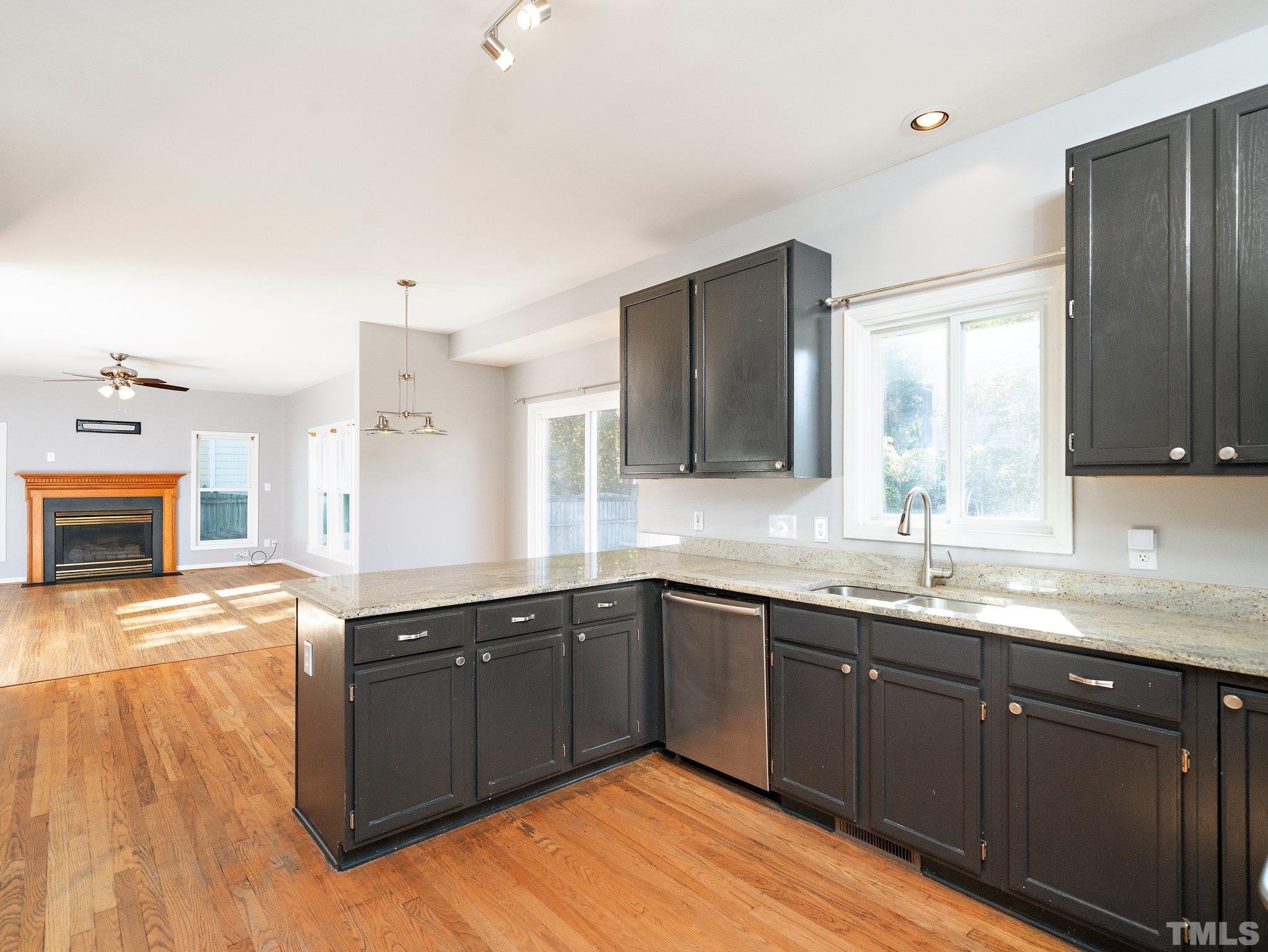 9821 Rockledge Drive Raleigh, NC 27617 - Photo 9 of 26 a kitchen with granite countertop a sink cabinets and wooden floor